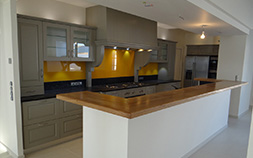 Aménagement d'une cuisine bois de couleur grise chic style cottage avec porte à cadre et plan en granit noir à Montauban