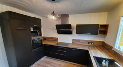 Cuisiniste Sanchez réalise une cuisine style industriel porte noire et plan de travail bois à Montech