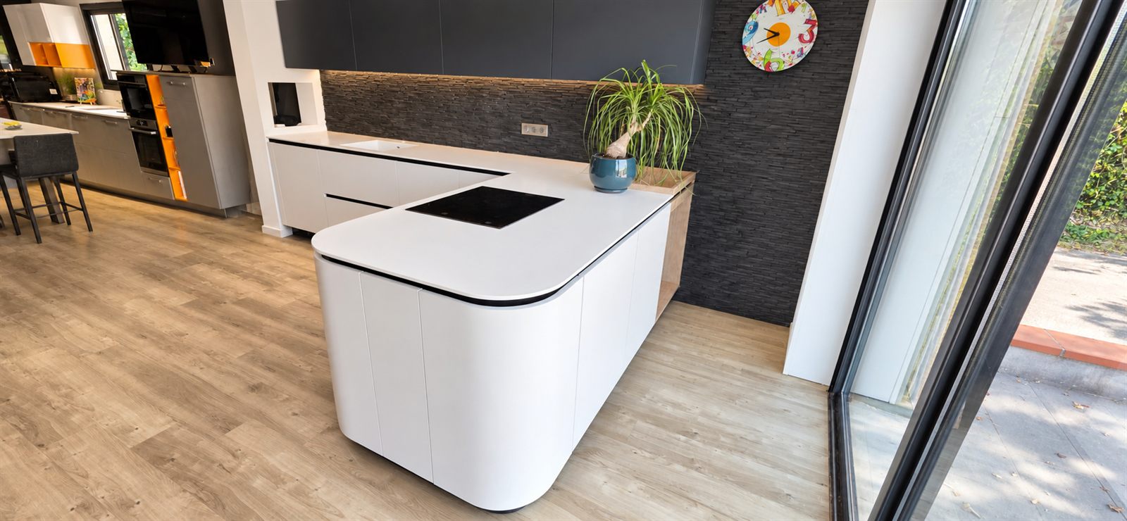 Îlot de cuisine arrondi aux formes organiques dans le showroom Cuisines Sanchez